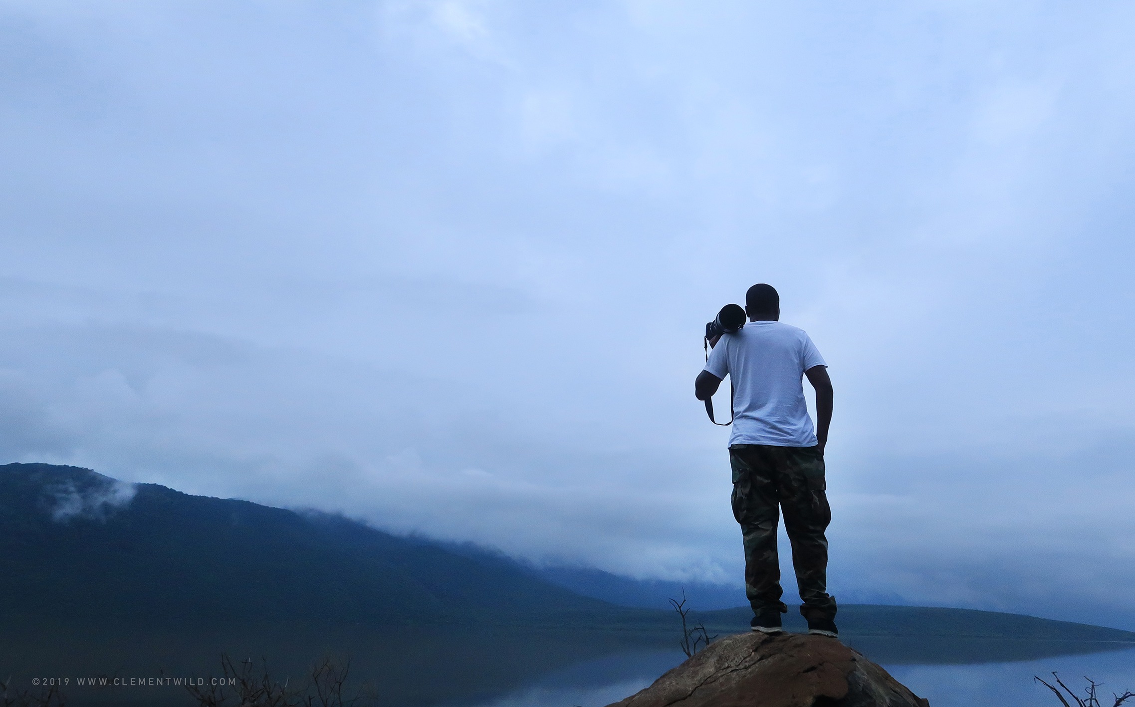 Clement Kiragu | Clement Wild holding a wildlife camera on a lake